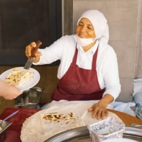 Turkish Woman making Tortillas on a wooden rustic table.